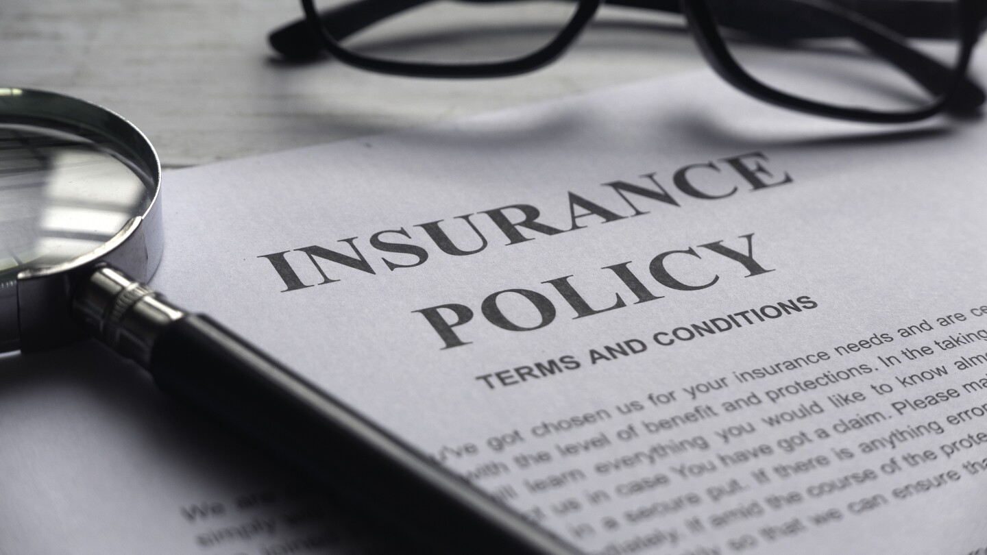 Selective focus of magnifying glass,glasses and Insurance Policy letter on a white wooden background.