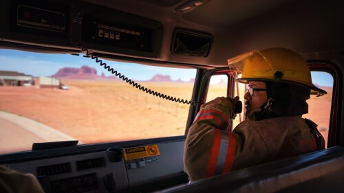 Firefighter using the fire engine radio responding to an emergency call