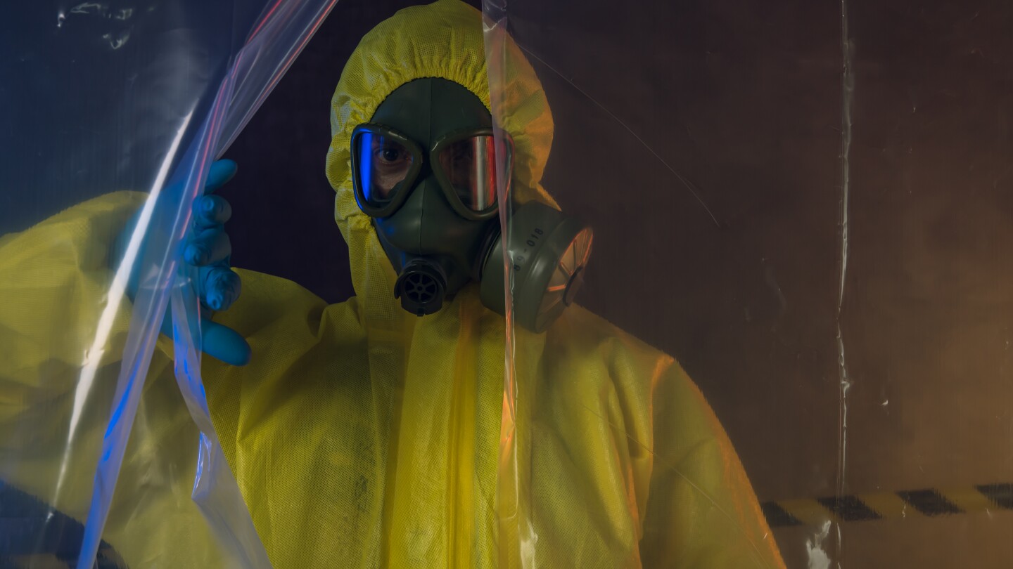 Man with gas mask and yellow protective suit, top secret government project.