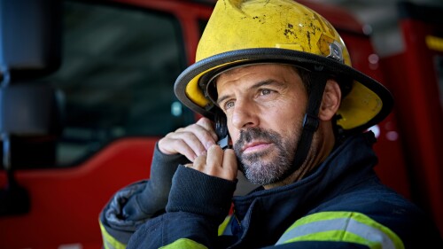 Bearded Firefighter in Mid 40s Putting on Helmet