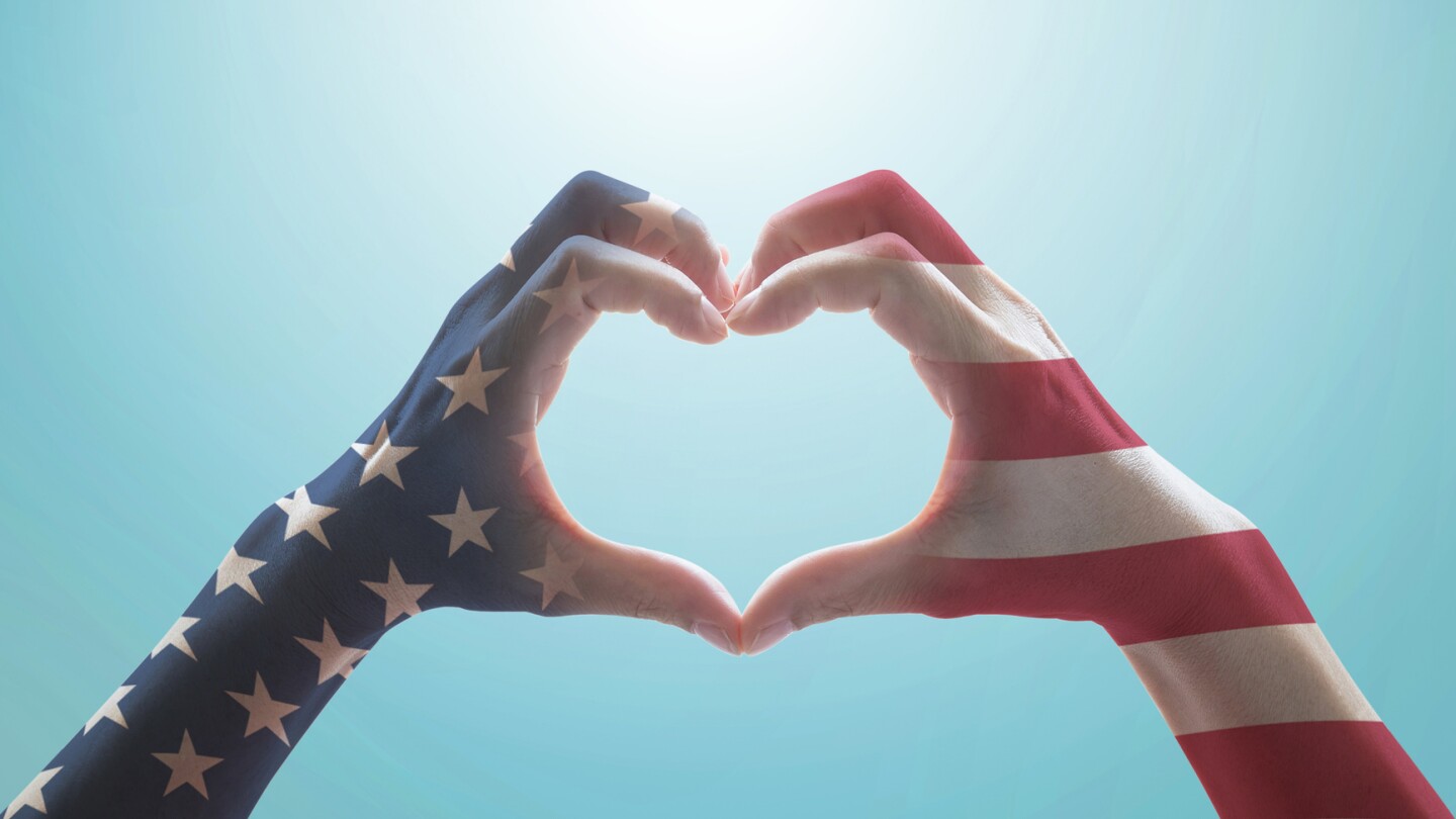 American flag pattern on people hands in heart shaped form against vintage sky background w/ clouds: Memorial day Happy columbus day Patriot day, USA Independence Labor Loyalty day symbolic concept