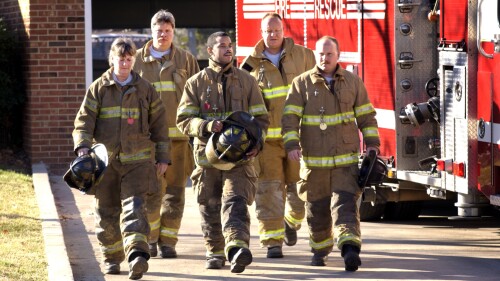 Firefighters walking by fire engine